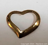Close-up photo of the 14K yellow gold floating heart pendant showing smooth polished surface and hollow center in the shape of a heart.