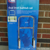 Front view of the packaged Carex dual level bathtub rail showing product name and features.