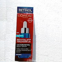 Front view of L'Oreal Revitalift Triple Power LZR Night Serum box with blue and red colors and silver dropper bottle illustration.