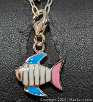 Close-up of tropical fish pendant on sterling silver necklace showing enamel colors and clasp.