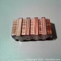 Top view of the wooden puzzle box wrapped in plastic, showing the striped pattern of wooden slats.