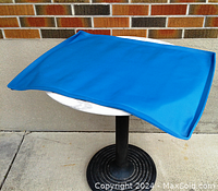 Blue silicone pet food mat displayed flat on a round table, showing full size and flexible material.