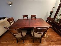 Table set up with chairs removed showing rectangular top and parquet pattern