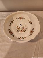 Top view of the bone china dish showing floral and butterfly pattern with scalloped edges.