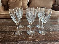 Group of six crystal wine glasses on wooden table