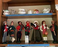 Seven Byers Choice Carolers figurines on shelf