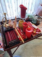 Lot contents on tray with amber fairy light, brass horn candle holder, assorted red and yellow candles.