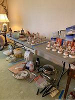 Wide view of folding tables set up with various household items on and around them.