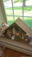 Front view of wooden stable with full set of porcelain nativity figurines