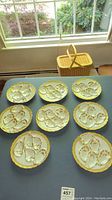 Overview of eight round oyster plates laid out on table in front of window