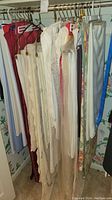Assorted table linens hanging on rack, showing variety of designs and materials