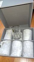 One displayed tumbler and five wrapped in original compartments inside open Waterford box.