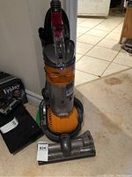 Full view of Dyson Ball DC24 upright vacuum with accessories.