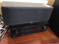 Pioneer receiver with Paradigm speaker stacked on top.