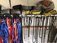 Shelf with various tiedown straps in different colors and bungee cords hanging beneath