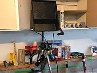 Wide view of the lot arranged on shelf showing paint tray, paint rollers, caulking guns, and several caulk tubes.