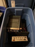 Multiple radio units piled inside blue storage tub