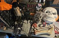 Wide view showing entire Halloween decoration lot on table including candelabras, skulls, bones, skeleton hands, spider webs and tape