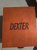 Closed wooden box engraved with the Dexter logo on the lid.
