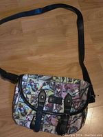 Front and side view of Black Widow comic strip purse showing colorful printed panels and black strap with buckle