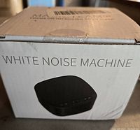 Closed box of the white noise machine showing product name and silhouette image of the device on the front.