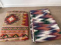 Two folded southwestern style throw blankets displaying distinct traditional patterns.