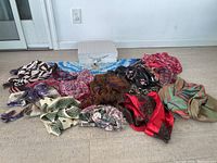 Overview of all scarves spread out next to white decorative box showing various colors and patterns