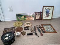 Overview of fishing themed decor and accessories arranged on floor including plaques, framed art, wooden fish, fishing line and sun plaque