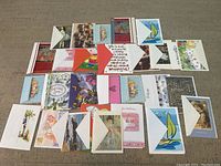 Multiple greeting cards and envelopes spread out on a surface showing a variety of designs and themes.