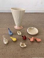 Full view of all Lenox porcelain items on a floor, showing vase, ashtray, and 8 colorful miniature bird figurines arranged around the vase.