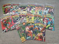 Fifteen comic books arranged on floor including one Plastic Man and fourteen Metamorpho the Element Man issues, assorted cover arts.