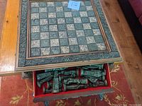 Drawer with carved chess pieces representing Mayans, in red velvet lined compartment.