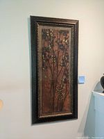 Full view of vintage botanical framed wall decor hanging on a light wall.