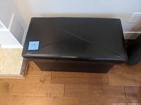 Top view showing the dark brown upholstered bench with diagonal stitching on the lid.