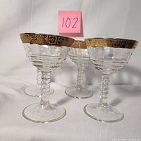 Photo showing three of the vintage cordial/sherry glasses with ribbed stems and gold floral banding at the rim.