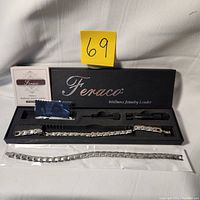 Overview photo of the two magnetic wellness bracelets/anklets in black Feraco branded box with tools, instructions, and an additional bracelet in plastic pouch.