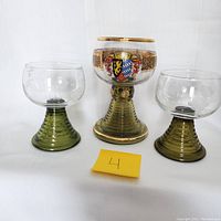 Front view of three Roemer glasses showing large goblet with Edenkoben Coat of Arms in center and two smaller beehive stemmed glasses on sides.