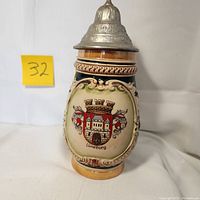 Front view of 8 inch German beer stein with metal lid, Luneburg crest and cobalt blue background.