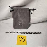 Photo showing the 8-inch Sabona magnetic stainless steel bracelet laid out with a grey drawstring pouch labeled 'Magnetic Jewelry'.