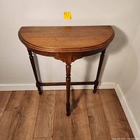 Front view of the demi lune wooden table showing half-round top and three legs