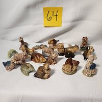 Full view of all 19 ceramic figurines from Wade Red Rose Tea collection arranged on white background showing variety of animals and figures