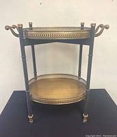 Front view of the two-tier bar cart with removable brass trays, showing overall structure and tray details.