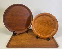 All three teak trays displayed on stands and flat on surface to show shape and relative size.