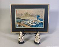 Full shot of lot including framed Japanese print with two resin figurines in front.