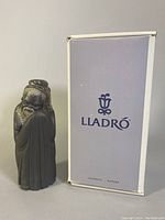 Front view of the Lladró figurine and the original white box with blue Lladró logo.