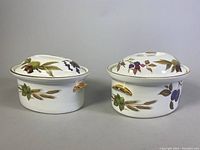 Two Royal Worcester Evesham oval covered casserole dishes side by side showing different sizes and designs
