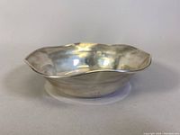 Side view of the silver scalloped bowl showing shape and condition.