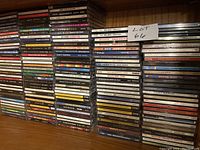 Photo of many stacked CDs showcasing various music titles and genres.