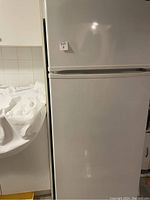 Front closed view of white fridge/freezer combo with two doors