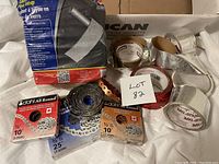 Box of galvanized strapping rolls, glass fiber pipe wrap, joint tape and tuck tape.